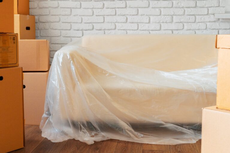 A packed sofa and cardboard boxes in the concept of relocating to Surbiton.