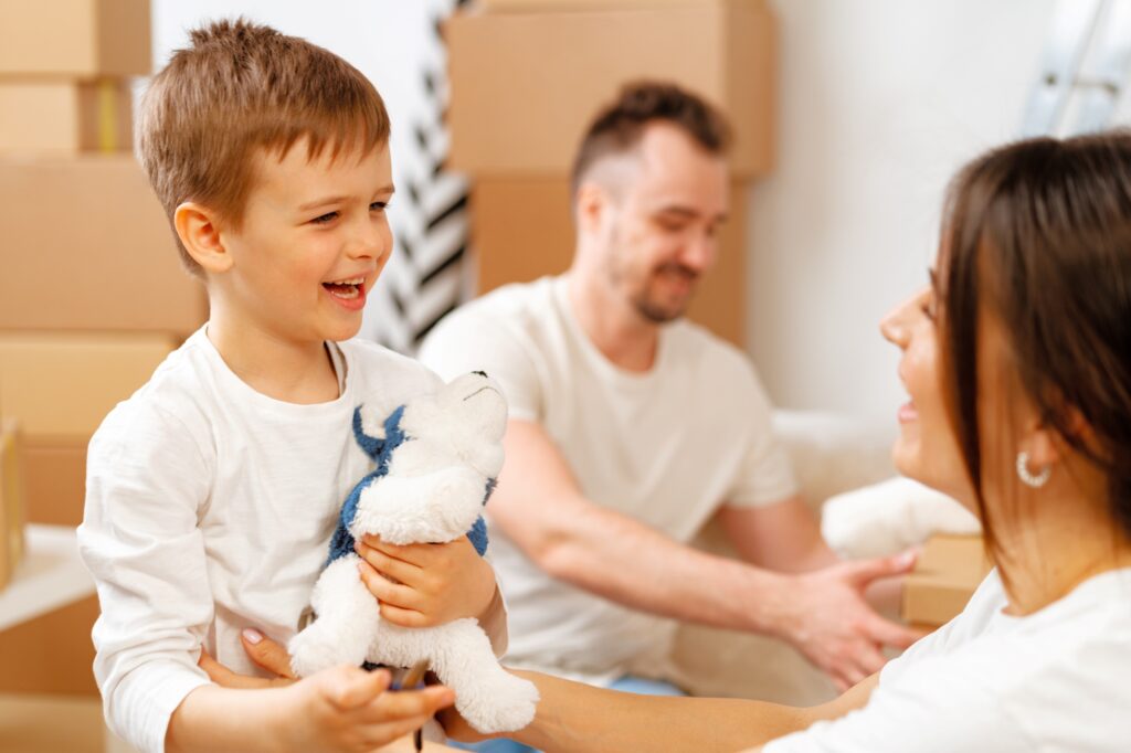 Portrait of a young family surrounded by cardboard upon moving in, in the concept of 'top services and amenities in Surbiton'.