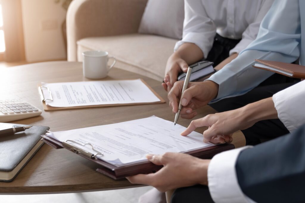 A cropped image of a customer signing a contract with the estate agent