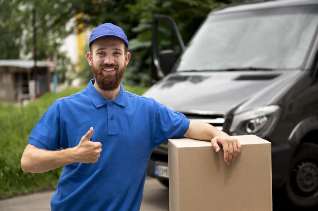 Medium shot of a Man in blue polo shirt with a box and a van in the background