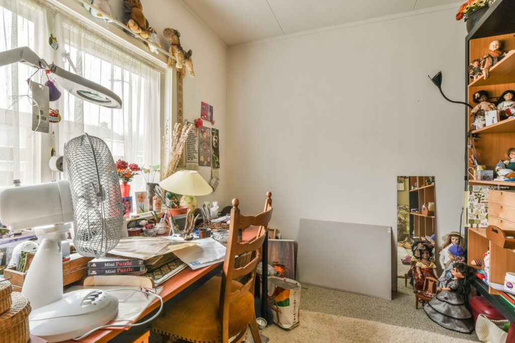 A bedroom with work desk full of souvenir items in the concept of 'What Factors Influence the Cost of a Man and Van Service'.