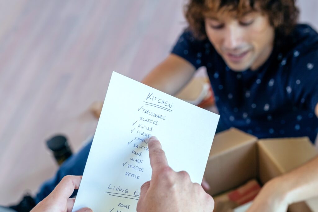 A couple rechecks their moving checklist and boxes in the concept of 'How to Create a Moving Checklist'.